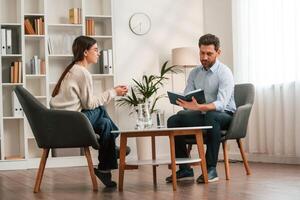 A session, with ,a psychologist. With woman. Doctor in formal clothes is working in the cabinet photo