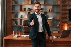 Greetings,, giving the hand. Businessman in formal clothes is working indoors photo