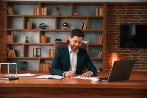 Businessman, in formal clothes, is working indoors photo