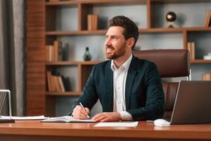 Thinking, having ,an idea. Businessman in formal clothes is working indoors photo