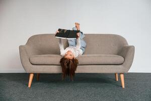 Little girl is ,lying down on the sofa at home. photo