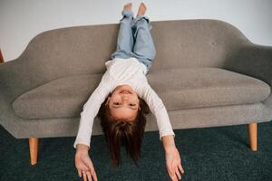 Little girl, is lying down on the sofa at home photo