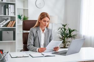Doing paperwork. ,Woman in business formal clothes is working in office photo
