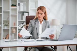 Doing ,paperwork. Woman in business formal clothes is working in office photo