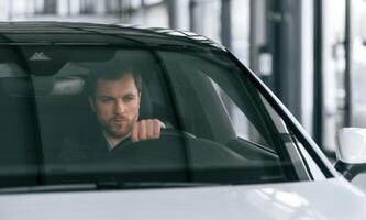 Serious facial ,expression. Driving the car. Man in formal business clothes is sitting in the modern automobile photo