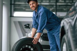 Man in blue ,uniform is working in the car service photo