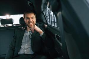 In ,comfortable modern automobile. Man in formal business clothes photo