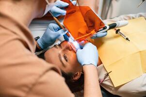 Procedure of installation of aligner in progress. Woman in the stomatology clinic, visiting dentist photo