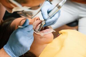 Using tools ,to install the aligner. Woman in the stomatology clinic, visiting dentist photo