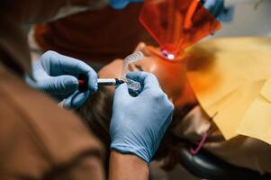 Using tools to, install the aligner. Woman in the stomatology clinic, visiting dentist photo