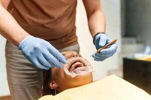 Lying on ,a chair. Installation of aligner. Woman in the stomatology clinic, visiting dentist photo