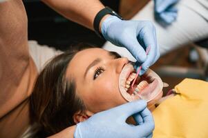 Using, tools to install the aligner. Woman in the stomatology clinic, visiting dentist photo