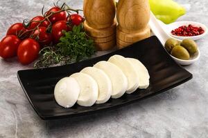 A plate of cheese and other ingredients on a counter photo