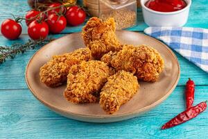 Fried chicken on a plate with ketchup and tomatoes photo