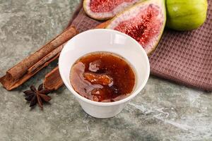 Figs, cinnamon and an apple on a table photo