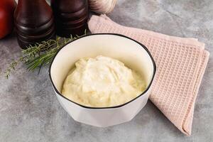A bowl of cream cheese next to a bowl of garlic photo