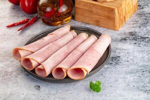 Ham slices on a plate with a knife and pepper photo