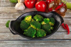 Broccoli in a bowl on a wooden table photo