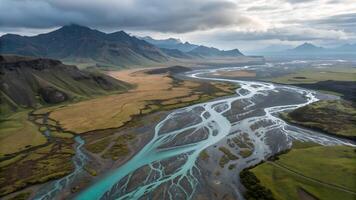 Aerial view of a braided river in Iceland, with intricate water patterns weaving through a rugged landscape under a cloudy sky. photo