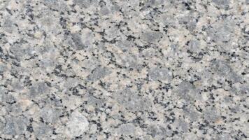 A close up of a polished granite surface showcasing a beautiful blend of gray, white, and black speckles, ideal for backgrounds or texture in design projects. photo