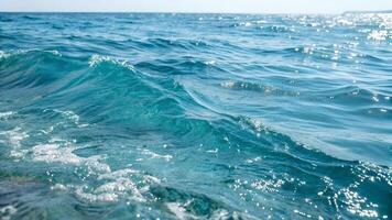 Crisp, turquoise ocean waves glisten under the sun, capturing the essence of a serene and vibrant seaside atmosphere. photo