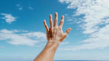 Reaching hand against bright blue sky with clouds, expressing hope and freedom photo