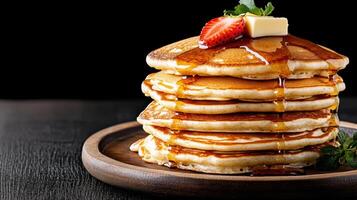 Fluffy pancakes stacked high, drizzled with syrup and topped with butter photo