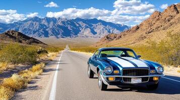 classic muscle car parked on desert road with mountains in background photo