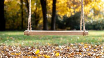 wooden swing sways gently in serene autumn park, surrounded by fallen leaves photo