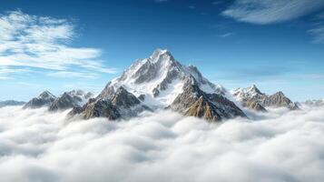 Majestic mountain range rising above thick clouds under clear blue sky photo