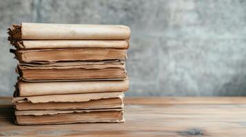 Old, dusty scrolls stacked on wooden table in library setting photo