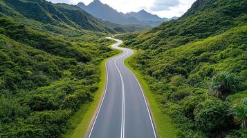 Winding mountain road through lush green hills and valleys photo