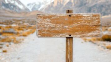 Weathered wooden signpost in mountainous landscape, inviting exploration photo