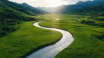 serene drone view of winding river through lush green fields and mountains photo