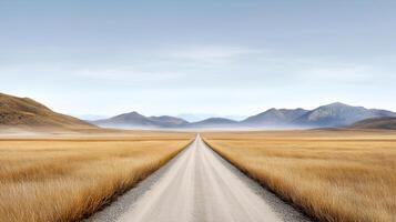 serene dirt road stretches through golden grasslands towards distant mountains photo