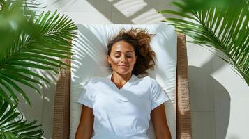 Relaxing woman on sunbed surrounded by lush greenery and sunlight photo
