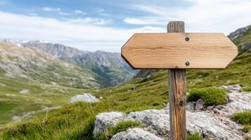 wooden signpost on rocky hillside with scenic mountain view photo
