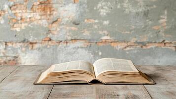 open book resting on rustic wooden table against weathered wall photo