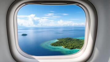 Aerial view of tropical island and deep blue ocean from airplane window photo