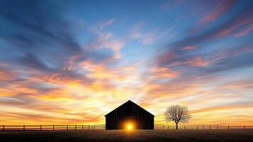 dramatic silhouette of barn at sunset with vibrant clouds and tree photo