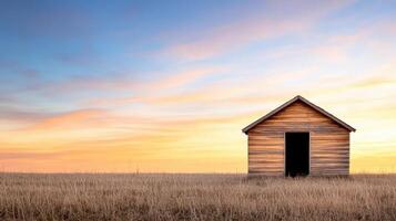 serene wooden shed stands alone in golden field at sunset photo