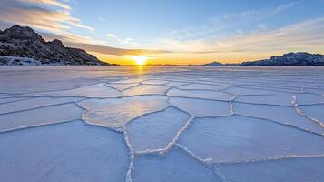 breathtaking sunrise over vast frozen lake with intricate ice patterns photo