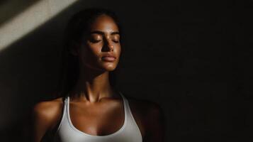 serene woman in stretching pose, illuminated by soft light photo