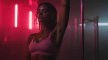 woman in pink sports bra poses confidently in gym with neon lights photo