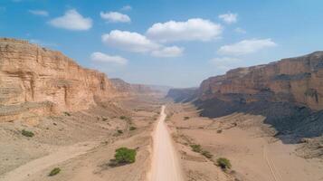 deep canyon with dramatic rock formations and sandy road photo