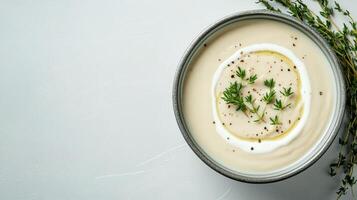 Creamy soup topped with cream and fresh herbs, perfect for comfort photo