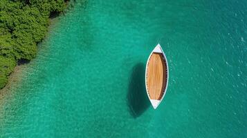 Aerial view of fishing boat on clear turquoise water near lush greenery photo