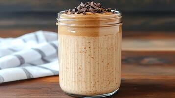 Creamy peanut butter smoothie topped with chocolate chips in jar photo
