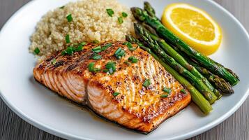 delicious heart healthy salmon dish with quinoa and asparagus, garnished with lemon photo