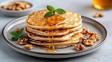 Delicious pancakes stacked high, drizzled with syrup, and garnished with mint photo
